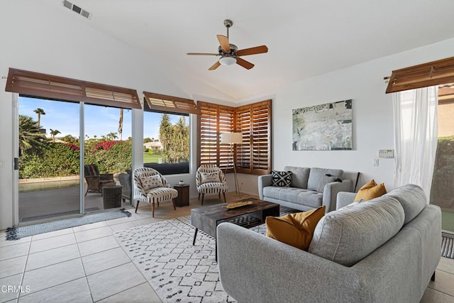 living room with ceiling fan, plenty of natural light, light tile patterned flooring, and vaulted ceiling