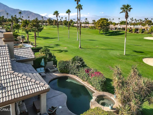 view of home's community with a mountain view and a hot tub