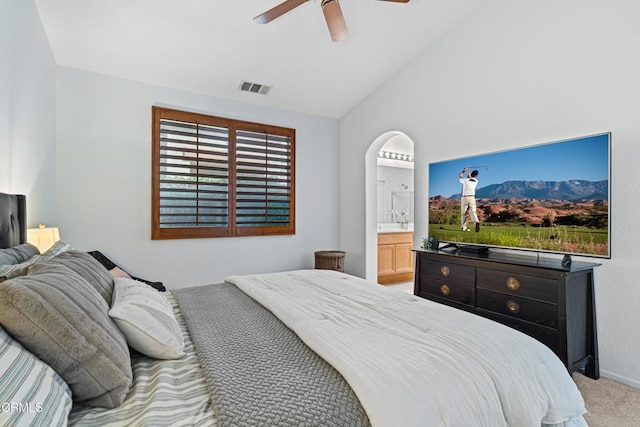 bedroom featuring connected bathroom, ceiling fan, light colored carpet, and vaulted ceiling