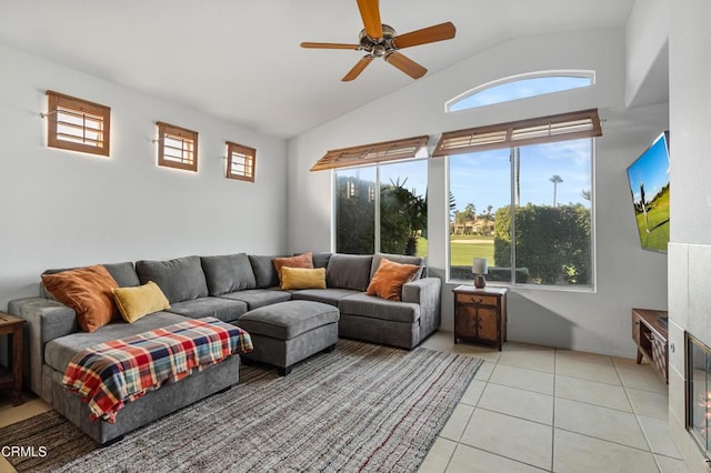 living room featuring plenty of natural light, light tile patterned flooring, a fireplace, and ceiling fan