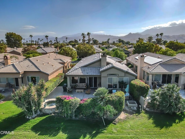 rear view of house featuring a yard, an outdoor hangout area, a mountain view, and a patio