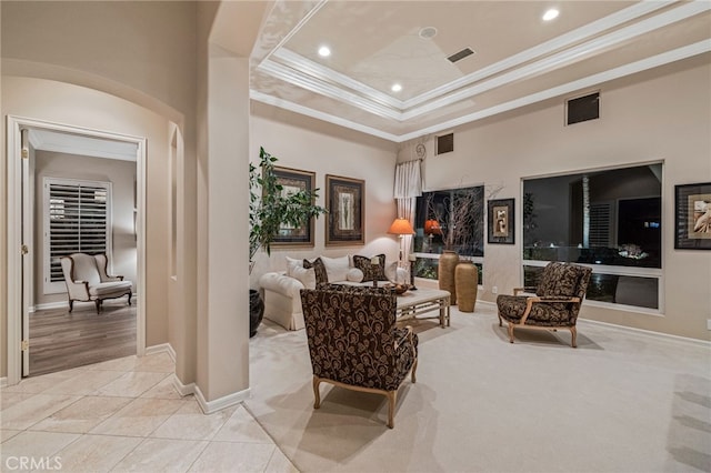 living area featuring light tile patterned flooring, a raised ceiling, and ornamental molding