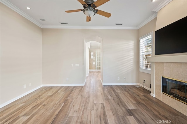 unfurnished living room featuring ceiling fan, a fireplace, ornamental molding, and hardwood / wood-style flooring