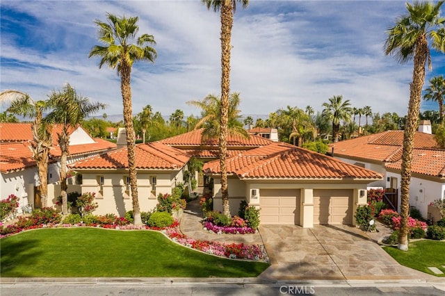 mediterranean / spanish house featuring a front yard and a garage