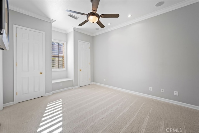 unfurnished bedroom featuring light colored carpet, ceiling fan, and crown molding