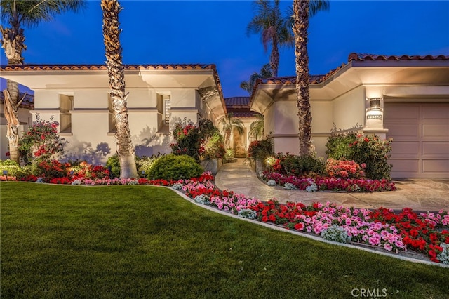 mediterranean / spanish-style house featuring a front lawn and a garage