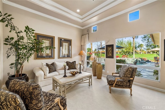 carpeted living room featuring a high ceiling, a raised ceiling, plenty of natural light, and crown molding