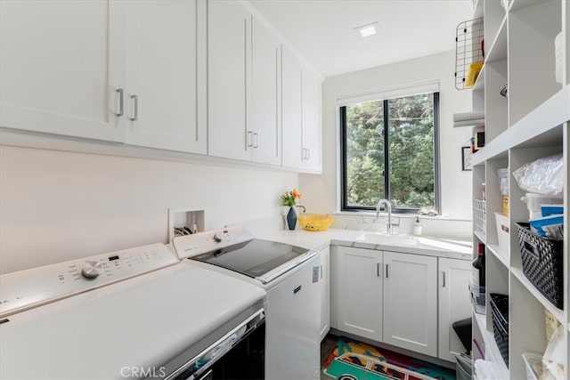 laundry room featuring sink, washing machine and dryer, and cabinets