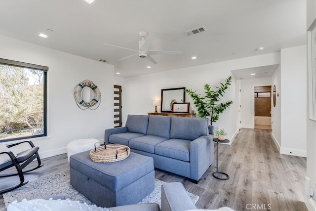 living room with light hardwood / wood-style flooring and ceiling fan