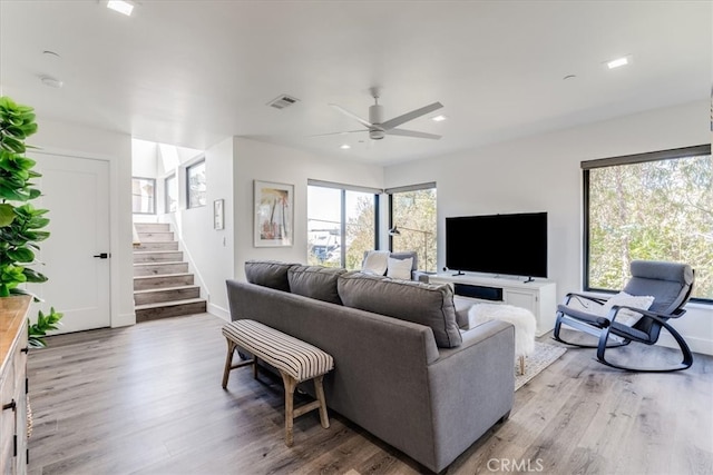 living room with light hardwood / wood-style flooring, ceiling fan, and plenty of natural light