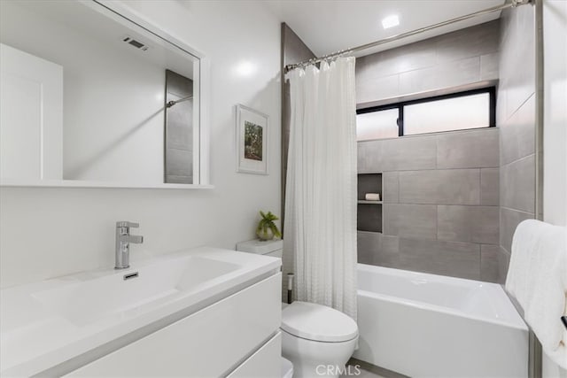 full bathroom with vanity, shower / bath combo with shower curtain, and toilet