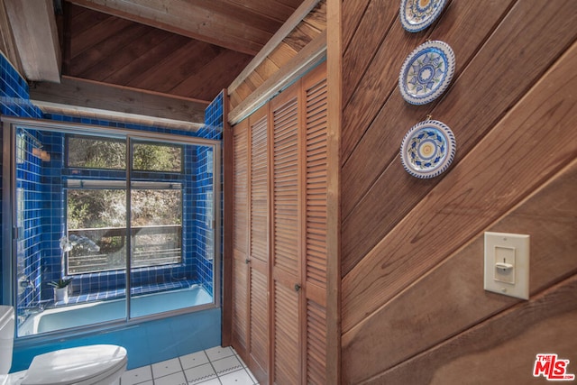 bathroom with shower / bath combination with glass door, wooden ceiling, tile patterned floors, wooden walls, and toilet