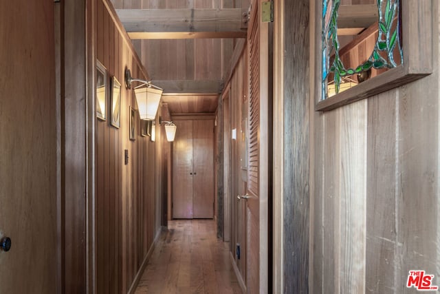 corridor with wood-type flooring and wooden walls