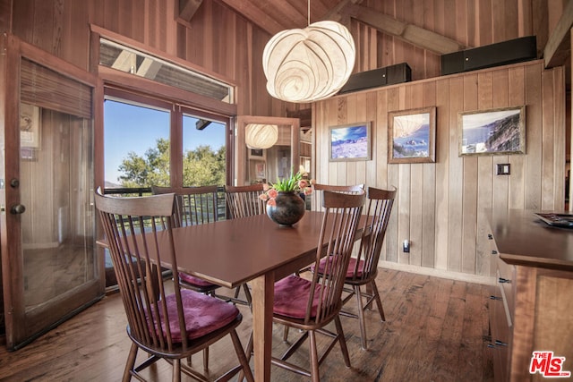 dining room with hardwood / wood-style floors, beam ceiling, and wooden walls