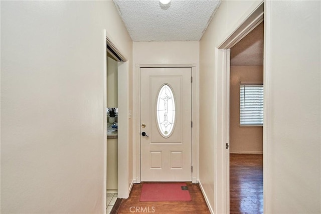 entryway with dark hardwood / wood-style flooring and a textured ceiling