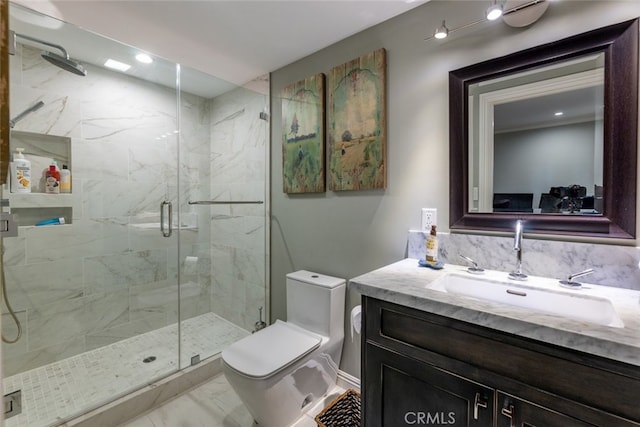 bathroom with vanity, toilet, and a shower with door