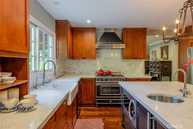 kitchen with light stone countertops, sink, wall chimney exhaust hood, dark hardwood / wood-style flooring, and appliances with stainless steel finishes