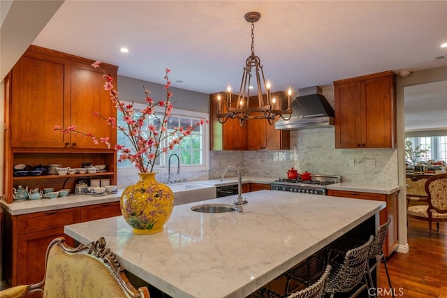 kitchen featuring wall chimney exhaust hood, dark wood-type flooring, a wealth of natural light, and an island with sink