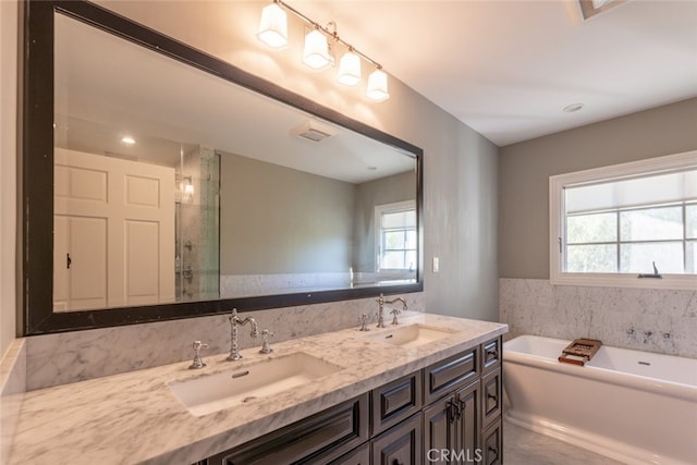 bathroom featuring vanity and independent shower and bath