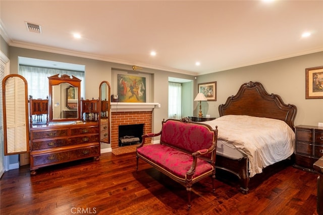 bedroom featuring ornamental molding, a brick fireplace, and dark wood-type flooring