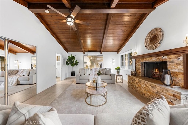 living room featuring beamed ceiling, wooden ceiling, a high end fireplace, and light hardwood / wood-style flooring