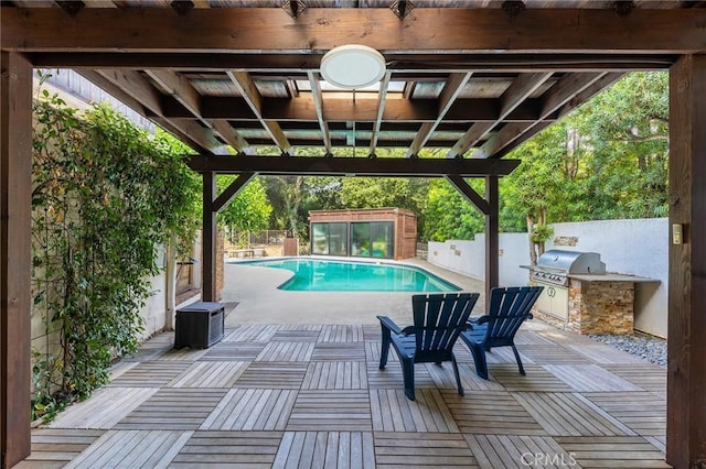 view of pool featuring an outdoor kitchen, a patio area, and grilling area