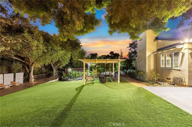 yard at dusk featuring a pergola