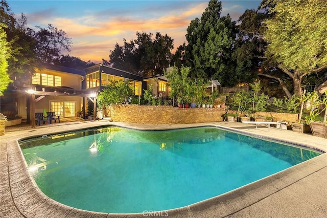 pool at dusk with a patio