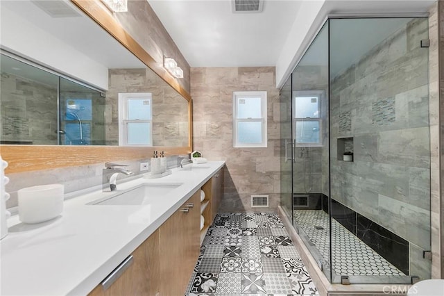 bathroom featuring backsplash, an enclosed shower, vanity, tile walls, and tile patterned flooring