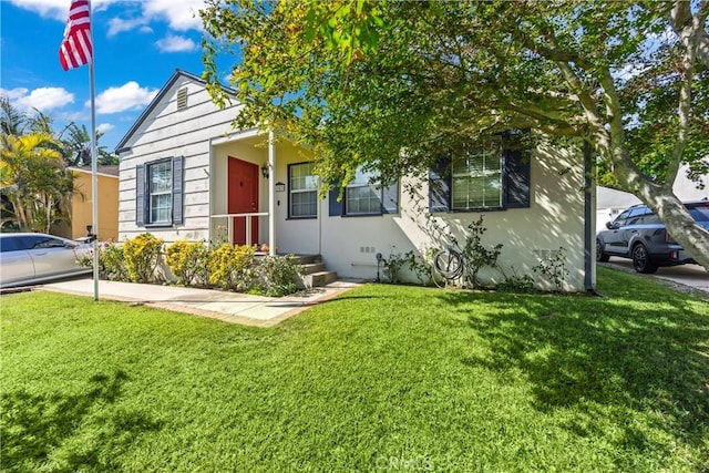 bungalow with a front lawn and stucco siding