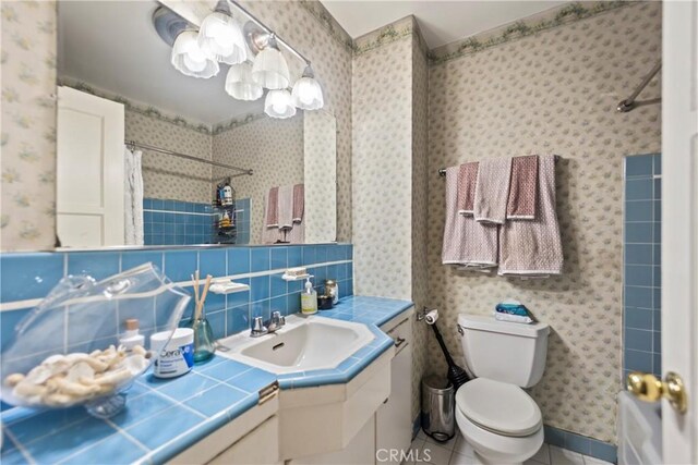 bathroom featuring tasteful backsplash, toilet, vanity, curtained shower, and tile patterned flooring