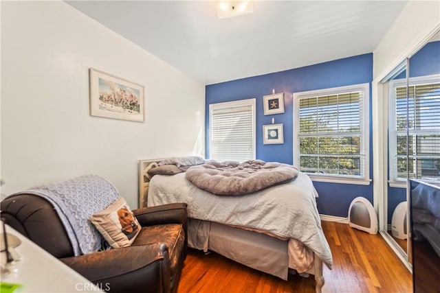 bedroom with baseboards and wood finished floors