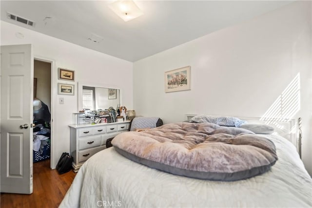 bedroom with dark wood-style floors and visible vents