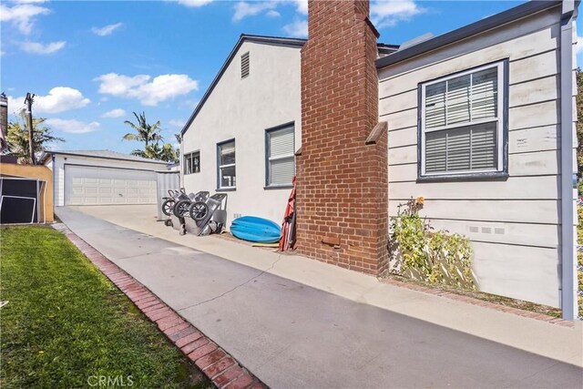 view of side of property featuring a garage and an outbuilding