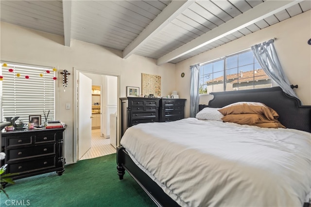 bedroom with ensuite bathroom, beamed ceiling, and dark colored carpet