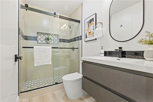 bathroom with toilet, walk in shower, vanity, and wood-type flooring