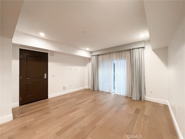 unfurnished room with light wood-type flooring