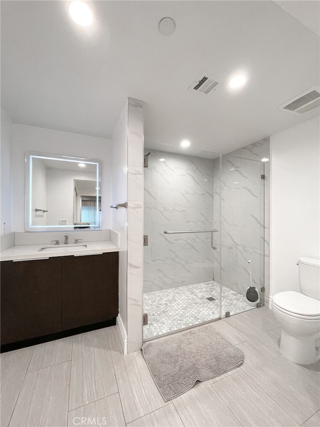 bathroom with toilet, an enclosed shower, and vanity