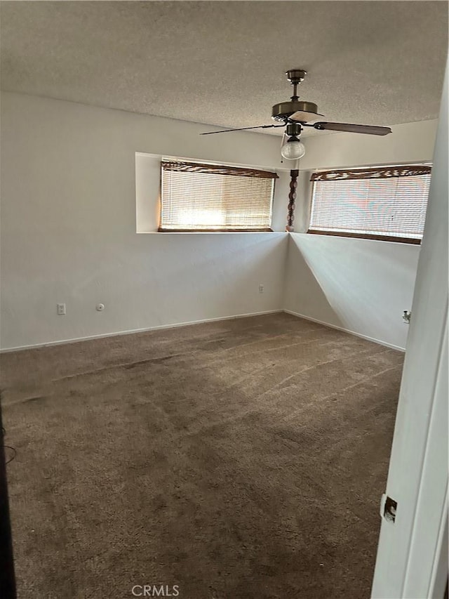 empty room with ceiling fan, carpet floors, and a textured ceiling