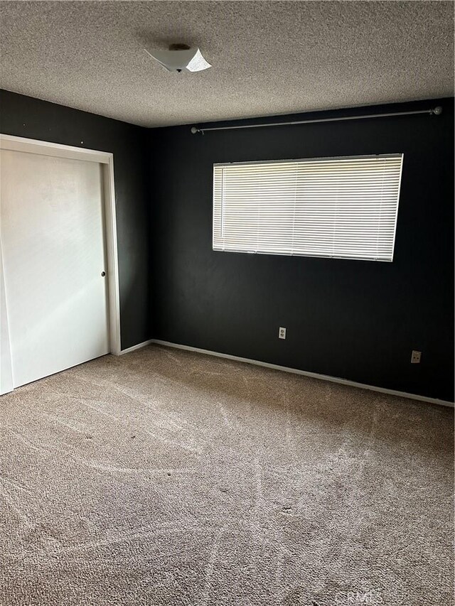 unfurnished bedroom with carpet flooring and a textured ceiling