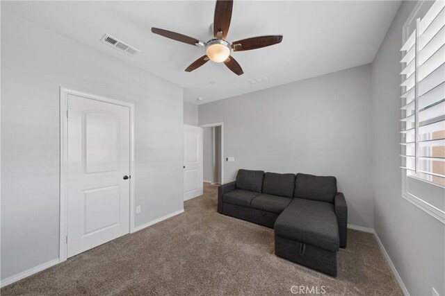 living area with carpet flooring and ceiling fan