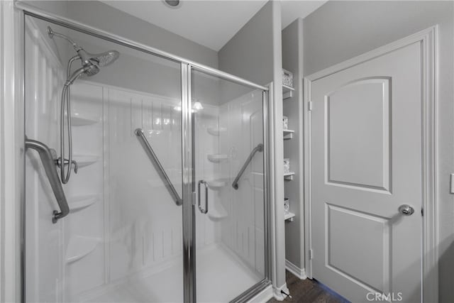 bathroom featuring hardwood / wood-style floors and a shower with shower door