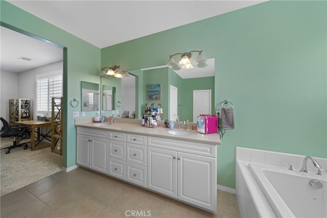 bathroom with vanity, tiled tub, and tile patterned flooring