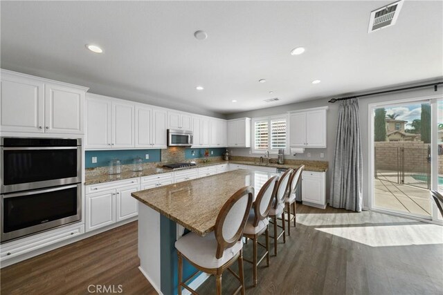 kitchen featuring white cabinets, stainless steel appliances, and dark hardwood / wood-style flooring