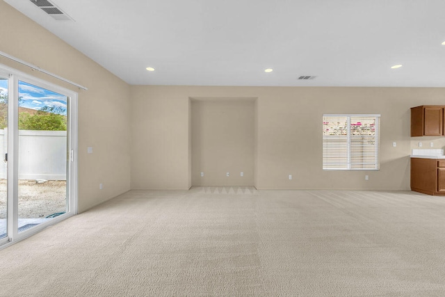 unfurnished living room featuring light colored carpet