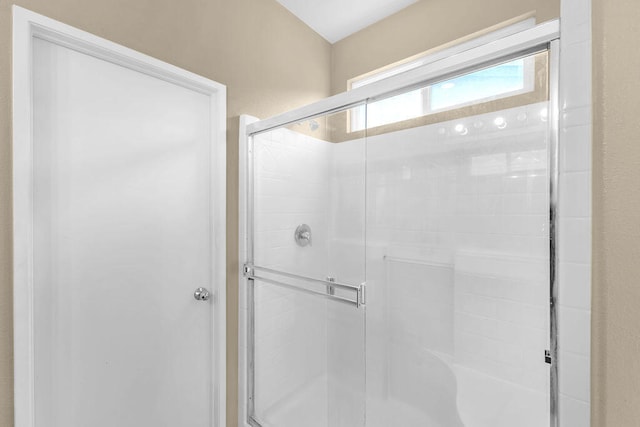 bathroom featuring a shower with door