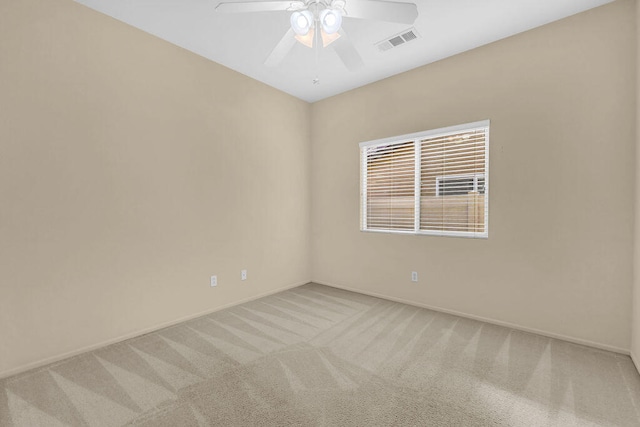 spare room with ceiling fan and light colored carpet