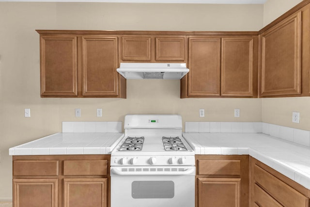 kitchen with tile countertops and white gas range oven