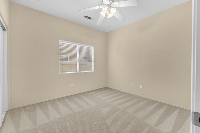 carpeted spare room with ceiling fan