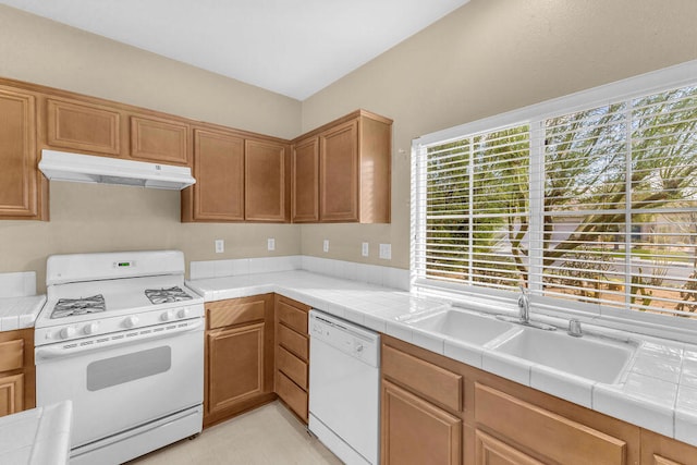 kitchen with tile counters, a wealth of natural light, and white appliances